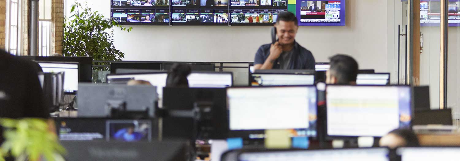 man using phone in front of TVs